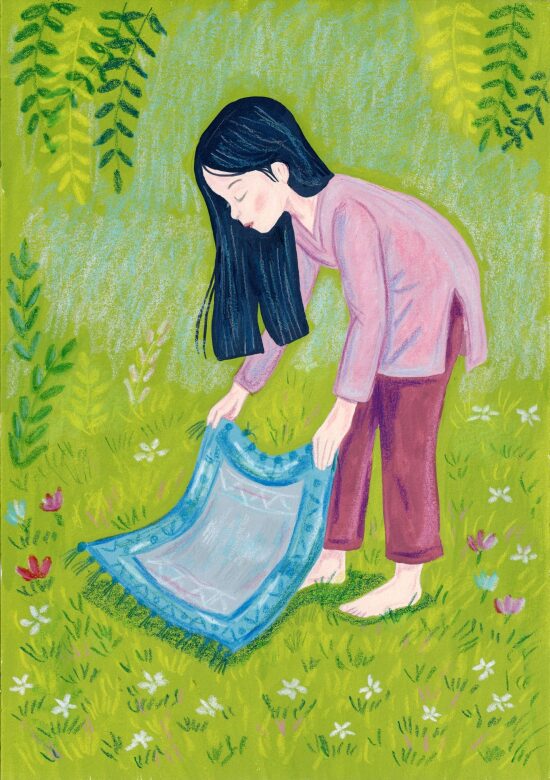 Fille dépliant un tapis dans l'herbe