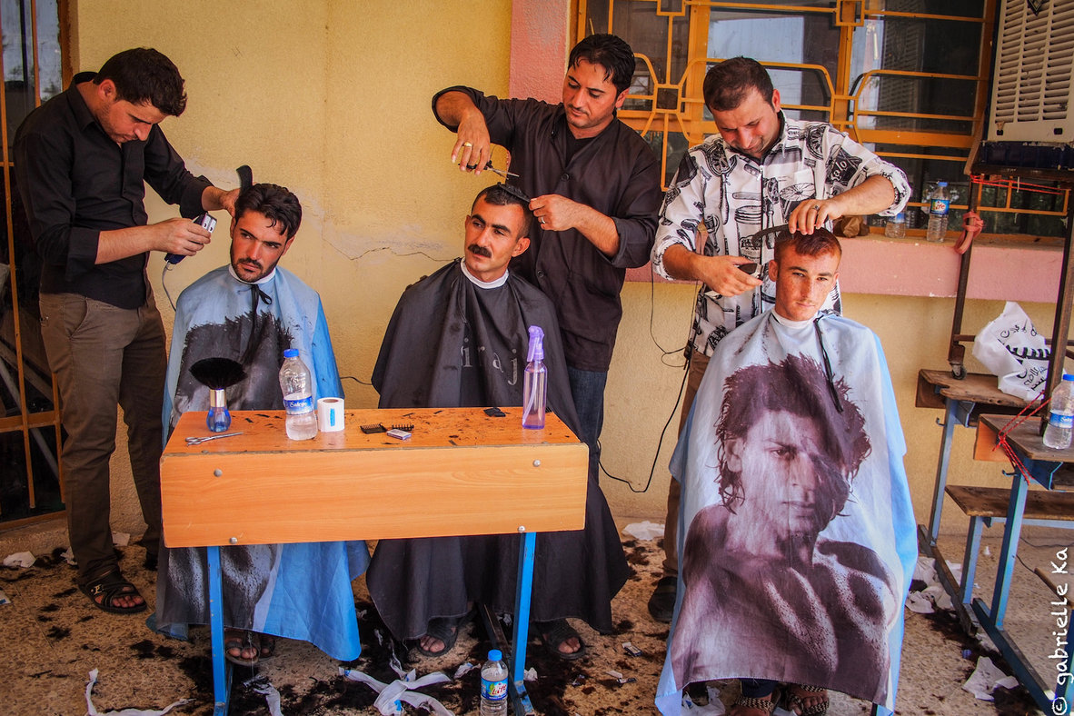 © Gabrielle Ka<br/><span>Sharya local inhbitants are giving free barber services to the Yazidis displaced hosted in the communal schools and other buildings.</span>
